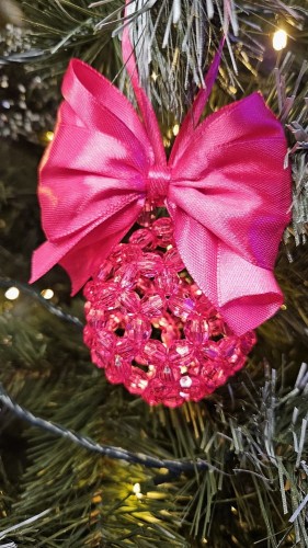 Ręcznie wykonana bombka z koralików w kolorze fuksji z dopasowaną wstążką, średnica 5–6 cm – intensywna świąteczna dekoracja handmade.