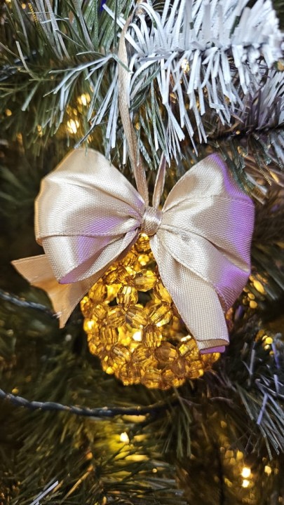 Ręcznie wykonana bombka z koralików w kolorze szampańskim z dopasowaną wstążką, średnica 5–6 cm – elegancka świąteczna dekoracja handmade.